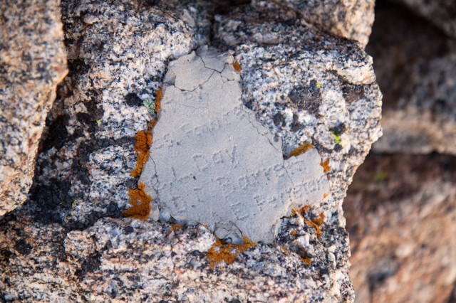 Old inscription that lists the names of the builders of the summit marker.
